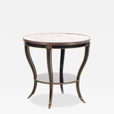 A French round marble top ebonized and gilt table C 1940 