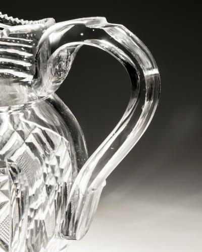 A HEAVILY CUT GLASS CREAM JUG