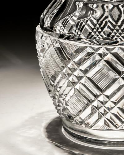 A HEAVILY CUT GLASS CREAM JUG