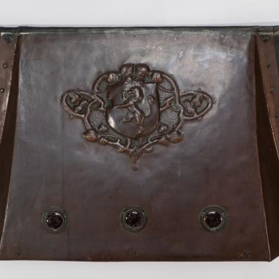 A Large Arts Crafts Copper Fire Insert with a Lion in a Shield Crest