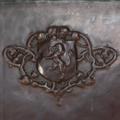 A Large Arts Crafts Copper Fire Insert with a Lion in a Shield Crest