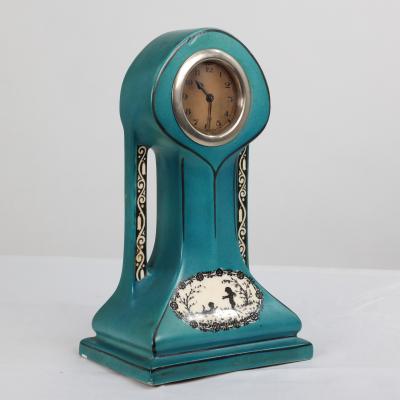 A Little Turquoise Blue Dressing Table Clock Decorated with Cherubs by a Tree