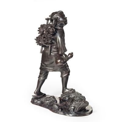 A Meiji period bronze of a boy carrying twigs