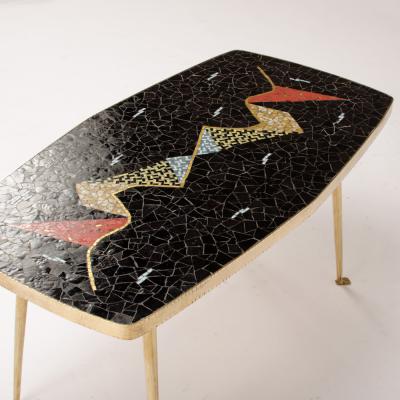 A Mid Century German coffee table with a mosaic top on brass metal legs