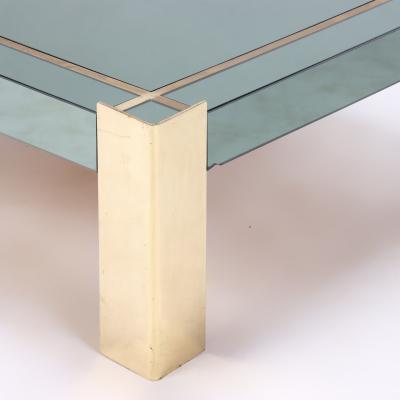 A Mid Century Modern coffee table with brass legs and trim Circa 1970
