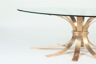 A Mid Century Modern oval bronze coffee table with a glass top France C 1960