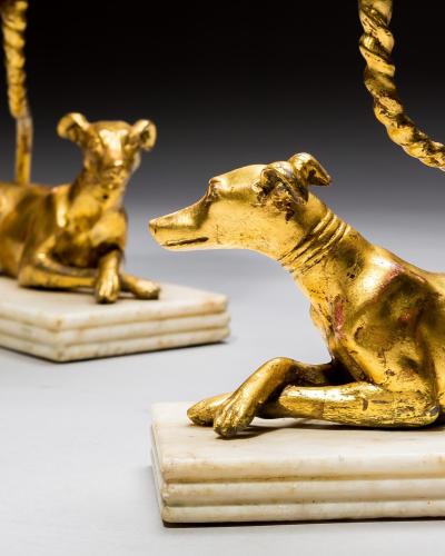 A PAIR OF GILT WOOD GREYHOUND CANDLESTICKS