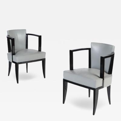 A Pair of French ebonized open arm chairs with faux leather upholstery C 1940