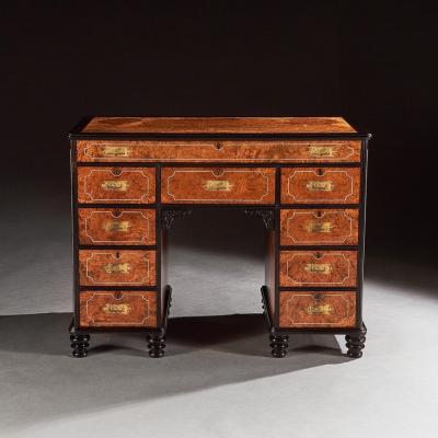 A RARE CHINESE EXPORT AMBOYNA AND EBONY CAMPAIGN KNEEHOLE DESK