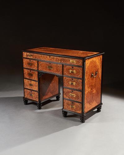 A RARE CHINESE EXPORT AMBOYNA AND EBONY CAMPAIGN KNEEHOLE DESK