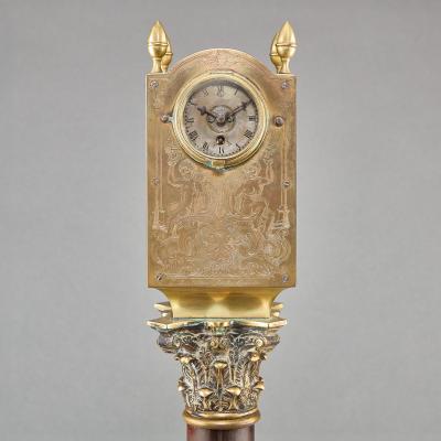 A REGENCY LANTERN CLOCK ON MAHOGANY AND EBONIZED BASE