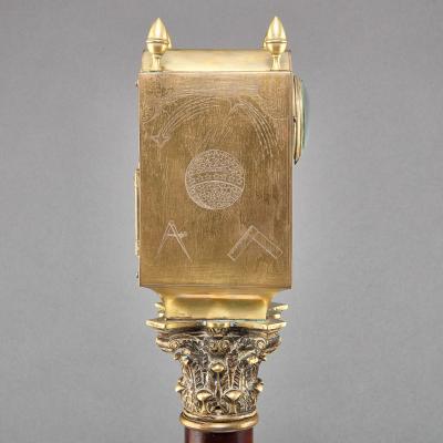 A REGENCY LANTERN CLOCK ON MAHOGANY AND EBONIZED BASE