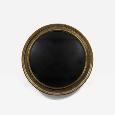 A Renaissance Revival Ebonized and Parcel Gilt Circular Convex Mirror