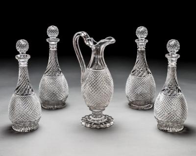 A SET OF FOUR DIAMOND SWIRL CUT DECANTERS WITH CORRESPONDING WINE EWER