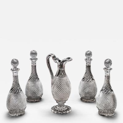 A SET OF FOUR DIAMOND SWIRL CUT DECANTERS WITH CORRESPONDING WINE EWER