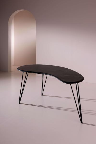 A bean shaped table made of dark slate and iron Italy late 1950s