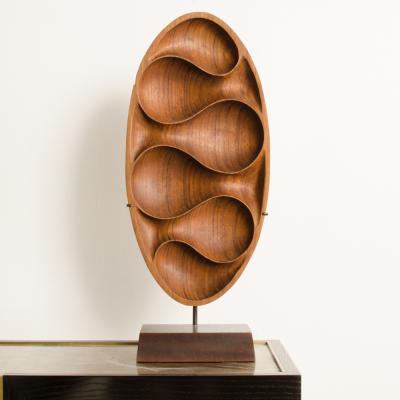 A carved wood almond shaped sculpture and base