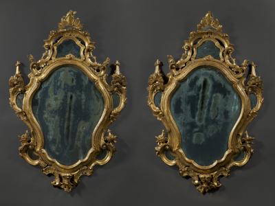 A fine pair of barocchetto escutcheon shaped giltwood mirrors cum girandoles
