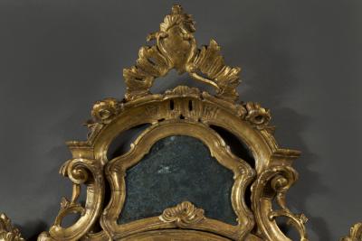 A fine pair of barocchetto escutcheon shaped giltwood mirrors cum girandoles