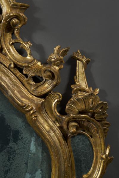 A fine pair of barocchetto escutcheon shaped giltwood mirrors cum girandoles