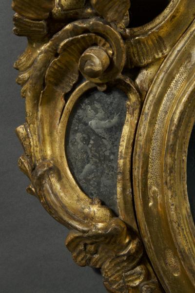 A fine pair of barocchetto escutcheon shaped giltwood mirrors cum girandoles