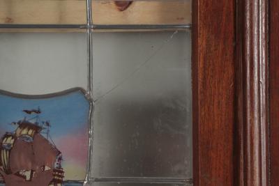 A four panel mahogany window set in frame with leaded glass having ship motif 