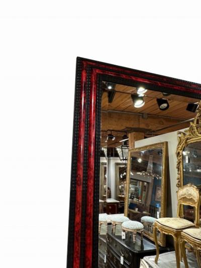 A large French ripple carved and faux tortoiseshell cushion mirror 