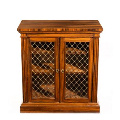 A late Regency Gon alo Alves two door side cabinet attributed to Gillows