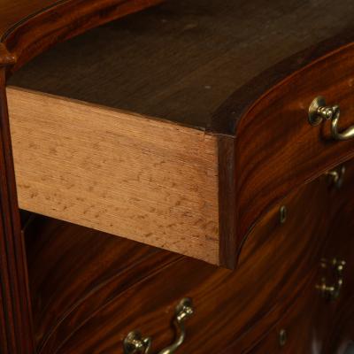 A mahogany four drawer serpentine chest of drawers