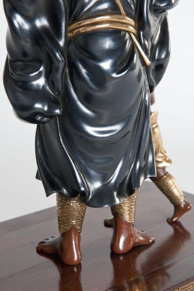 A meiji period bronze of an Oni holding a parasol