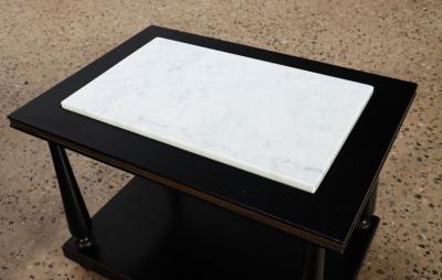 A pair of ebonized and gilt marble top end tables on ball feet circa 1950 