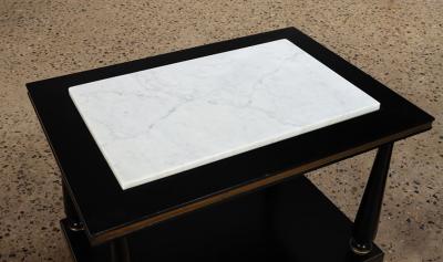 A pair of ebonized and gilt marble top end tables on ball feet circa 1950 