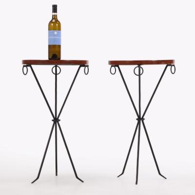 A pair of iron and mahogany drinks tables in the manner of Jean Michel Frank 