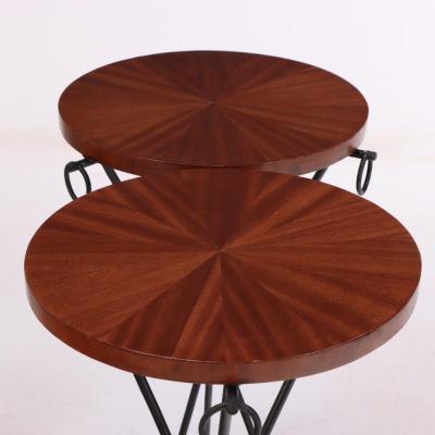 A pair of iron and mahogany drinks tables in the manner of Jean Michel Frank 