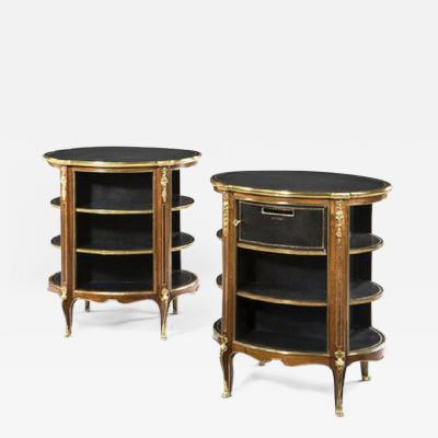 A pair of open library bookcases are inset with oval black leather tops