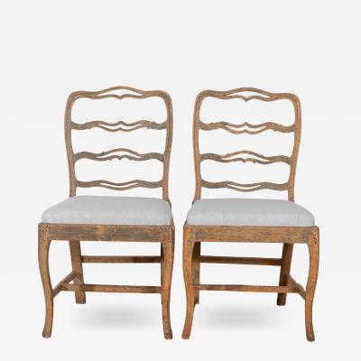 A pair of slender Gustavian chairs with smiling details Circa 1780
