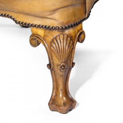 A pair of walnut wing armchairs in the Queen Anne style