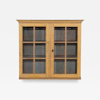 A period gustavian wall cabinet with glossed doors scraped to original paint