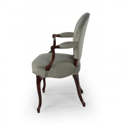 A rare set of twelve George III mahogany open arm chairs in the French Hepplewhi