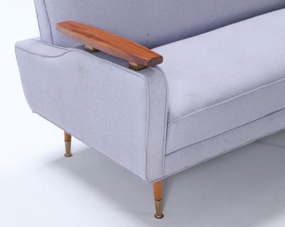 A restored sofa with floating wood arms and metal mounts circa 1960 