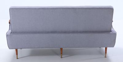 A restored sofa with floating wood arms and metal mounts circa 1960 