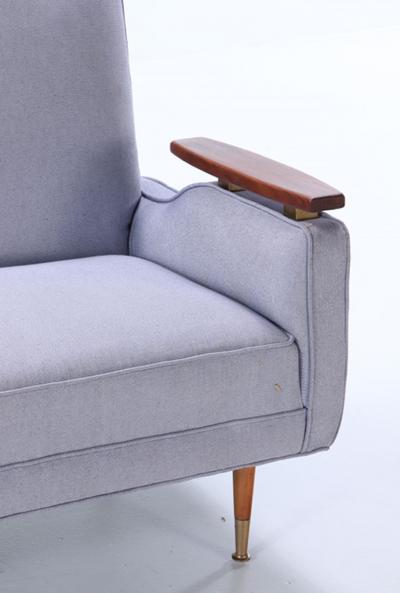 A restored sofa with floating wood arms and metal mounts circa 1960 