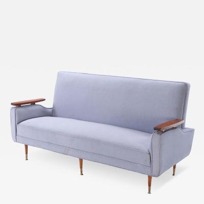 A restored sofa with floating wood arms and metal mounts circa 1960 