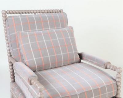A spool framed chair with upholstered seat back cushion semi attached bolster
