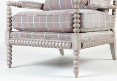 A spool framed chair with upholstered seat back cushion semi attached bolster