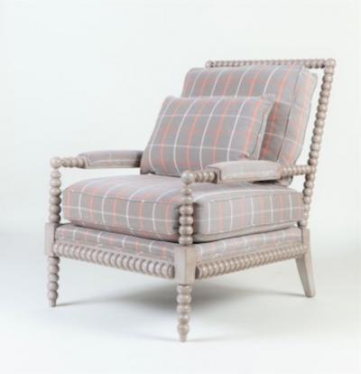 A spool framed chair with upholstered seat back cushion semi attached bolster