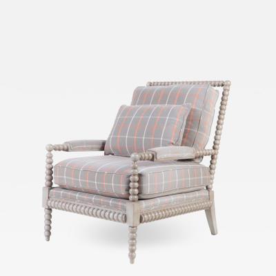 A spool framed chair with upholstered seat back cushion semi attached bolster