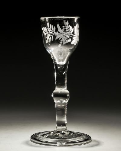 AN ENGRAVED PLAIN STEM WINE GLASS