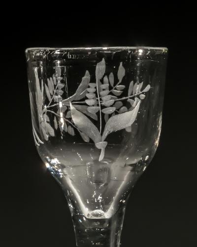 AN ENGRAVED PLAIN STEM WINE GLASS