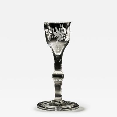 AN ENGRAVED PLAIN STEM WINE GLASS